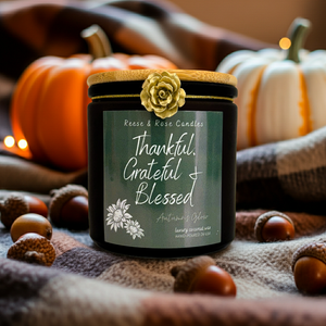 Jar of candles with a 'Thankful, Grateful, Blessed' label, surrounded by pumpkins and acorns on a textured fabric background.