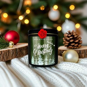 Candle with 'Merry Christmas' label in front of a decorated Christmas tree.