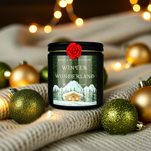 Candle labeled 'Winter Wonderland' surrounded by Christmas ornaments on a soft fabric background.